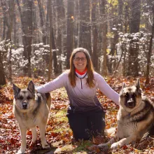 woman with 2 german shepherds in woods