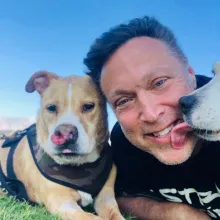 pit bull dog and man laying in grass