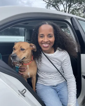 woman and dog in car with open door