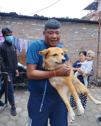 Man carrying injured dog