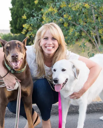 blonde woman between two large dogs