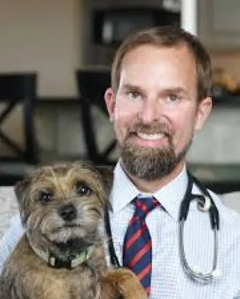 brown haired male doctor with dog