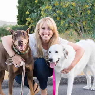 blonde woman between two large dogs